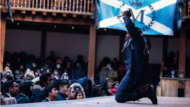  
Left: Ekow Quartey as Macbeth, with his banner proudly displayed by the student audience
